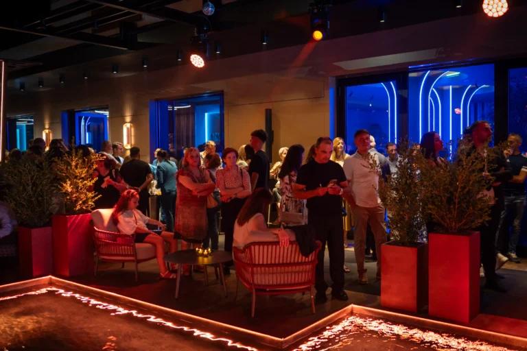Area lounge con ospiti e luci rosse durante una festa da Karapami Eventi, Giugliano in Campania
